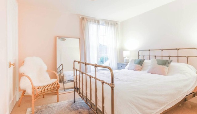 Juniper Cottage is a quaint, two-bedroom Grade II listed property featuring white wooden cladding.